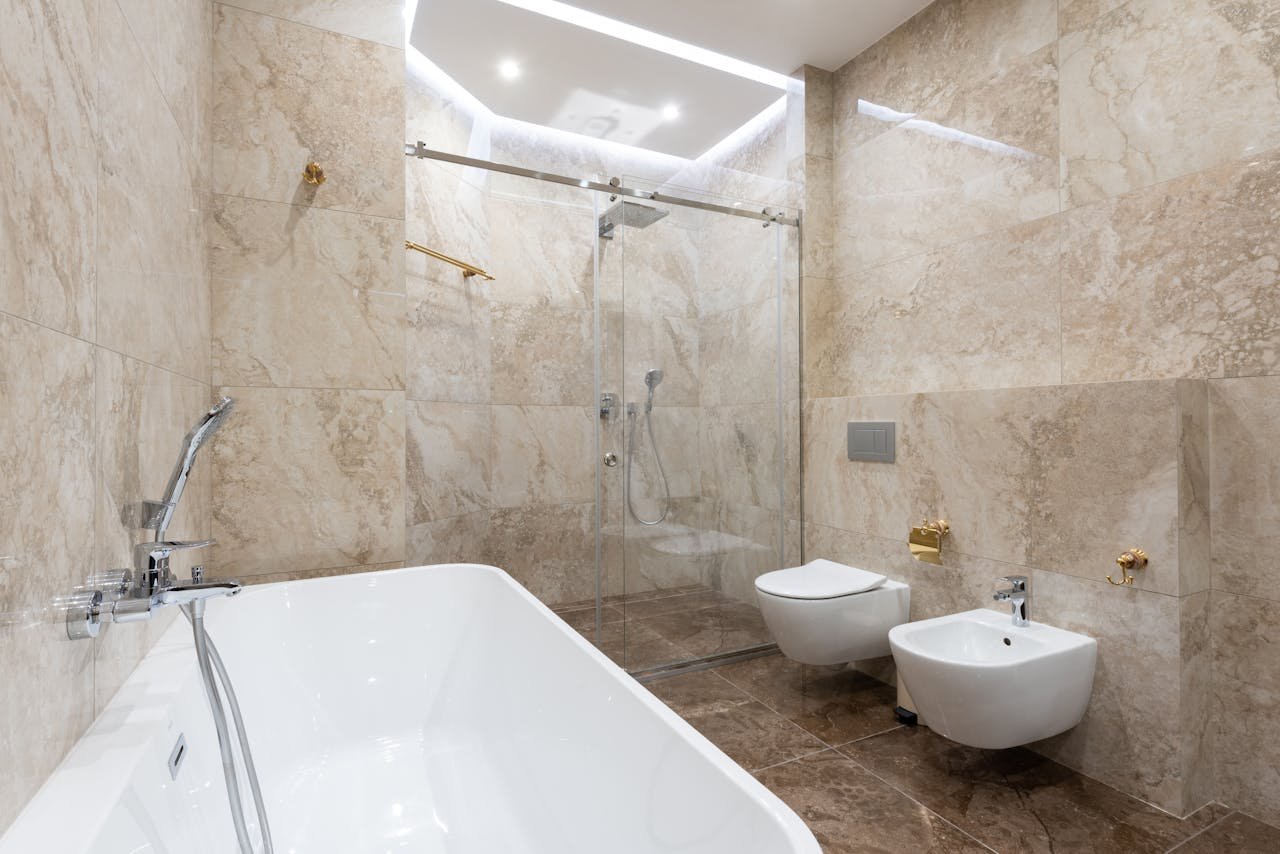 services-03 Interior of marble bathroom with glass shower cabin glowing with bright luminous lights